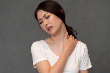 woman with shoulder or neck pain; portrait of asian woman suffering from shoulder or neck pain,...