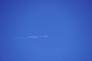 clear blue sky with random traces of burned fuel from the plane on a clear Sunny day.