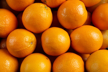Oranges fruit background. Closeup on a heap of oranges stacked togather. Orange texture that can be...