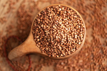 Buckwheat in bowl on table, spoons, top view 