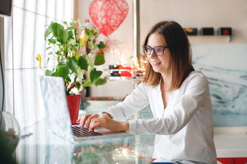 Caucasian emotional girl in glasses at laptop