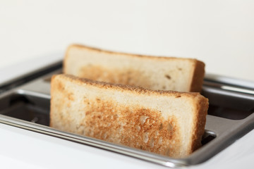 Slices of toasted bread in a white toaster.