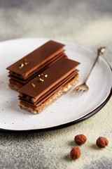 Chocolate layered cake with milk chocolate, praline, ganache, almond dacquoise