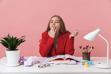 Yawning tired young woman sit at the table