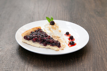 Sliced blueberry pie with fresh whipped cream and cookie crumble