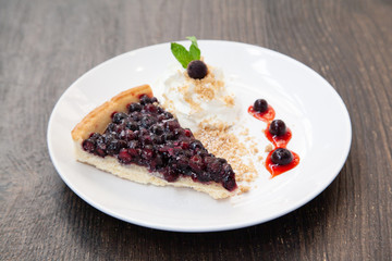 Sliced blueberry pie with fresh whipped cream and cookie crumble