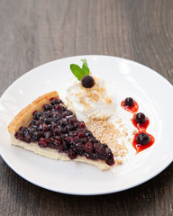 Sliced blueberry pie with fresh whipped cream and cookie crumble