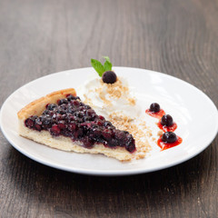 Sliced blueberry pie with fresh whipped cream and cookie crumble
