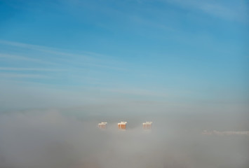 Fototapeta na wymiar Blue sky and high-rise buildings construction in the morning fog in distance.