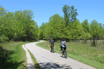 Man and woman riding bicycles on the North Branch Trail at Bunker Hill Woods in Chicago