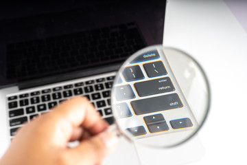 Obraz premium Magnifier and laptop with technology concept.