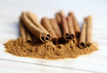 Cinnamon powder and sticks.   Aromatic spice of cinnamon on the white wooden table