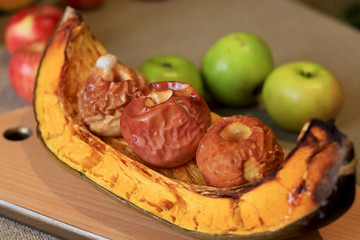 Baked pumpkin with apples on a wooden board