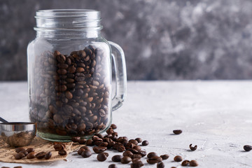 Coffee beans in a glass jar on a gray table