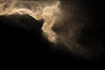Fototapeta na wymiar Dry river sand explosion.Brown color sand splash against black background.