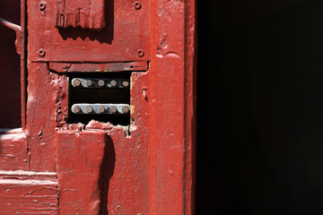 Red painted wooden door with a code lock