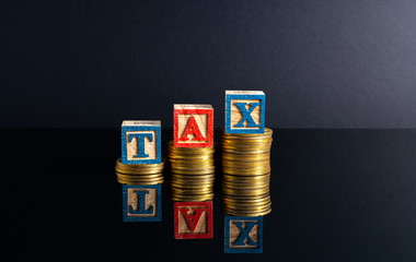 Coins stacking and tax letter cube with low light view.