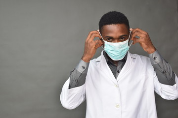 young black man wearing a white coat and face mask