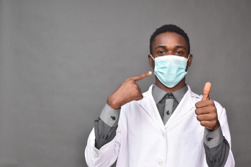 young black man wearing a white coat and face mask, indicating wearing a face mask for protection