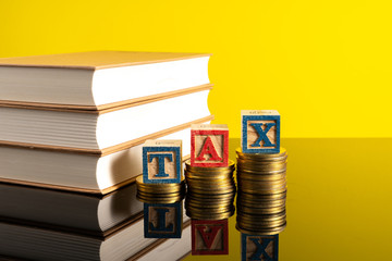 TAX letter and stacking coins with financial concept. Image in low light view.