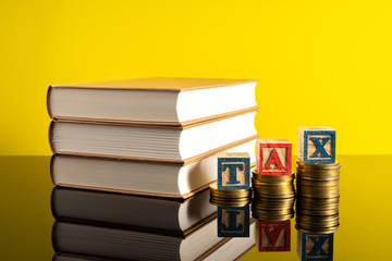 TAX letter and stacking coins with financial concept. Image in low light view.