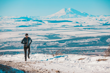 A man goes in for sports against the background of mountains