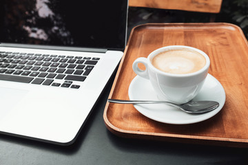 Coffee cup and laptop for business, Selective focus on coffee.