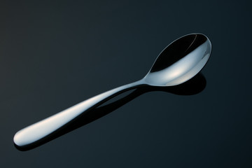 teaspoon on a black mirror surface