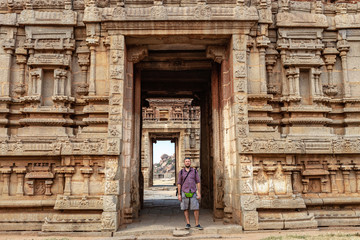 Fototapeta na wymiar Male tourist at the entrance to the temple. The Group of Monuments at Hampi was the centre of the Hindu Vijayanagara Empire in Karnataka state in India