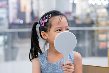 Little asian girl preparing for ear piercing process