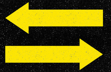 flèches jaunes de directions opposées sur asphalte 
