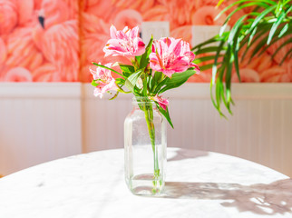 Colorful Flower Arrangement in a Glass Vase and Flamingo Wallpaper.