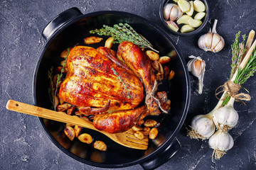 forty cloves chicken in a black baking dish