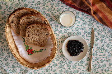 Wholemeal bread with marmalade to breakfast on a decorative tablecloth with a kitchen rag