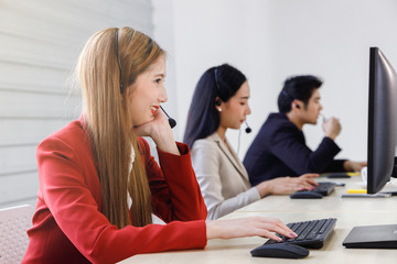 Happy female Asian call center support typing and smiling at computer screen. Concept for customer support service, office, employee.