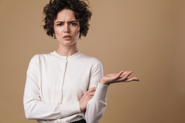 Image of displeased caucasian woman posing and holding copyspace