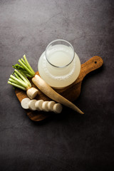 Healthy Fresh daikon juice or Mooli extract drink in a glass with raw mule