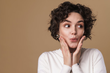 Image of excited beautiful woman expressing surprise at camera