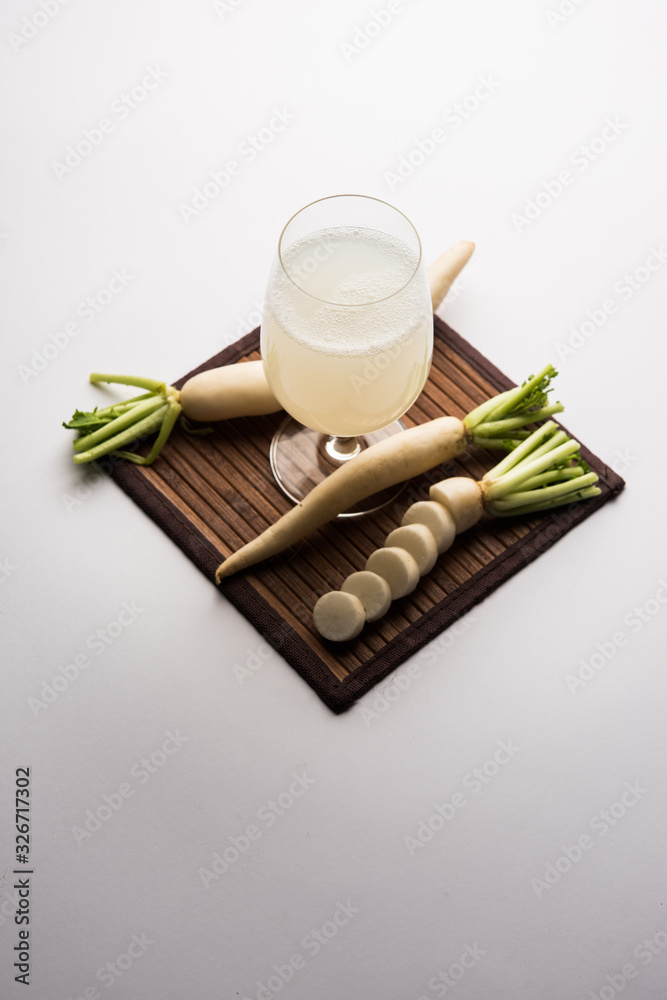 Wall mural Healthy Fresh daikon juice or Mooli extract drink in a glass with raw mule