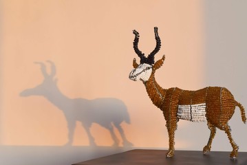 Toy antelope and its shadow on the wall