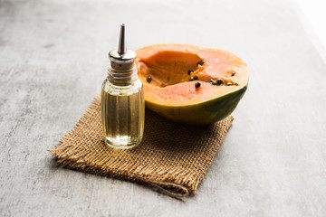 Papaya seed Oil with Raw Papita over moody background. selective focus