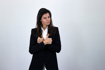 Portrait of positive caucasian bussiness woman keeps arms crossed and showing thumbs up gesture, isolated on gray background studio shot, white shirt and black jacket. Place for your text in copy spac