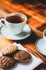 white cups and cookies on wooden table