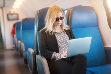 Businesswoman woman traveling using laptop in train