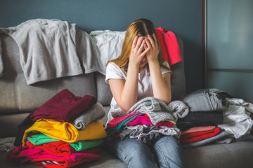 Fast fashion, the girl puts things in order in the closet. A bunch of colorful clothes. The concept...