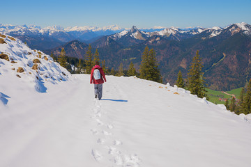 young woman at snowy wallberg mountain, hiking trail down, early springtime