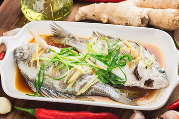 There is a plate of steamed sea bream on the table