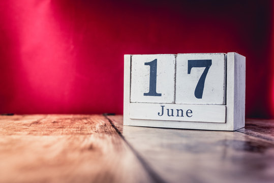 June 17th. Day 17 of month, calendar on business office table, workplace with vivid maroon red background. Summer time