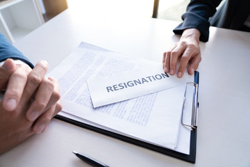 Businessman sending resignation letter to the executive employer boss on desk in order to resign dismiss contract, job placement and vacancies concept.