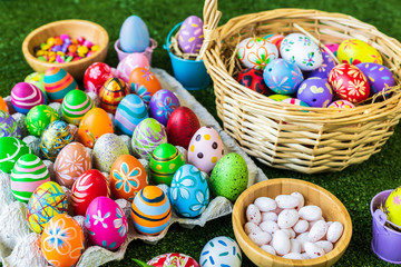 Easter holiday concept,Colorful Easter eggs in egg box,basket Easter eggs,candy basket,rabbit doll in green grass background with space.